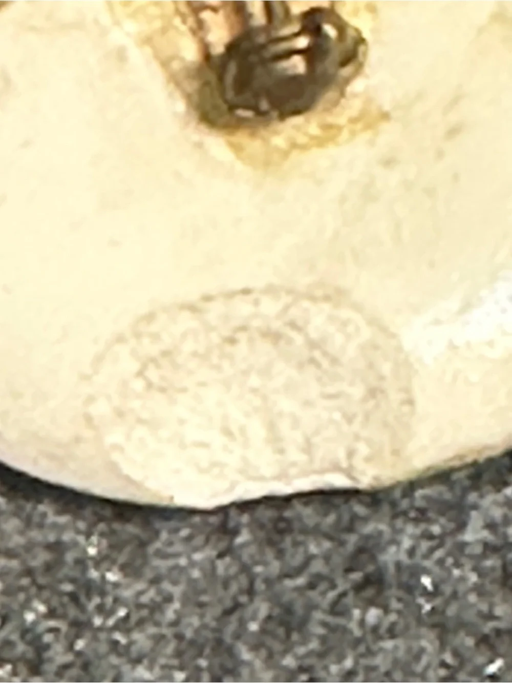 Small, hand-painted miniature artwork on a smooth stone or ceramic cabochon